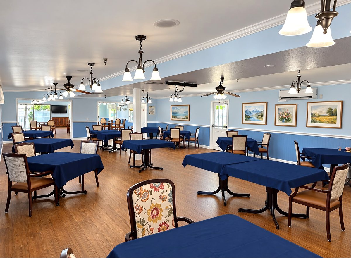 Dining tables dressed in new navy-blue tablecloths, with framed paintings on the walls